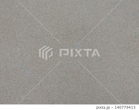 A fine-grained matte texture in a gray-beige color. The uniform, rough surface resembles polished concrete, granite chips, or plaster with occasional inclusions. The background is neutral and minimal A fine-grained matte texture in a gray-beige color. The uniform, rough surface resembles polished concrete, granite chips, or plaster with occasional inclusions. The background is neutral and minimal 140779413