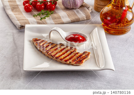 Grilled turkey steak with ketchup on white plate Grilled turkey steak with ketchup on white plate 140780116