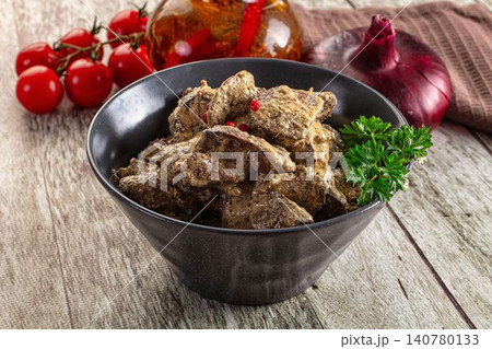 Creamy liver stew in black bowl with parsley garnish and cherry tomatoes Creamy liver stew in black bowl with parsley garnish and cherry tomatoes 140780133