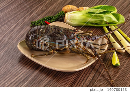 Fresh lobster with bok choy ginger lime and green peppercorns on wooden surface Fresh lobster with bok choy ginger lime and green peppercorns on wooden surface 140780138