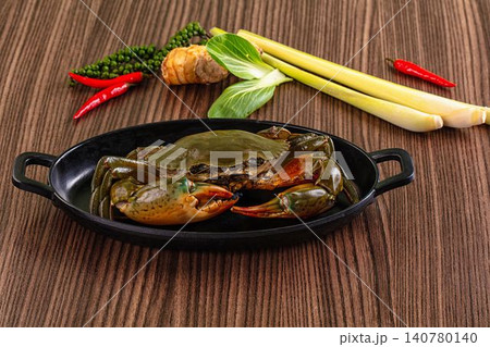 Fresh crab in black dish with lemongrass chili and peppercorns on wooden surface 140780140