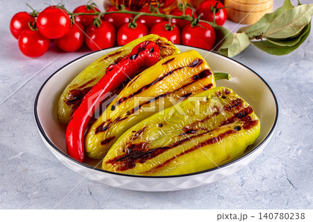 Grilled yellow and red peppers in white bowl with cherry tomatoes and bay leaves Grilled yellow and red peppers in white bowl with cherry tomatoes and bay leaves 140780238
