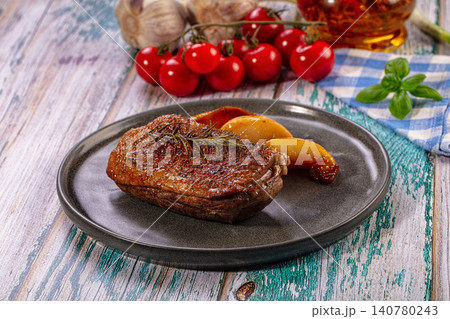 Roasted duck breast with rosemary and peach on rustic plate 140780243