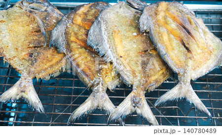 Top view of delicious deep-fried whole pomfret fishes, traditional Asian seafood menu background. Top view of delicious deep-fried whole pomfret fishes, traditional Asian seafood menu background. 140780489
