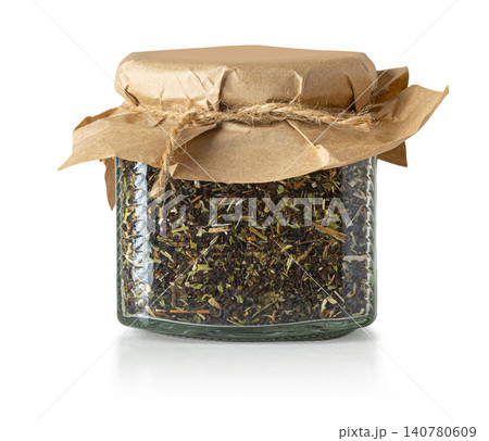 Glass jar with loose herbal tea blend and kraft paper lid 140780609