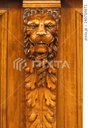 Ornate wood carving of a lion head on furniture Ornate wood carving of a lion head on furniture 140780671