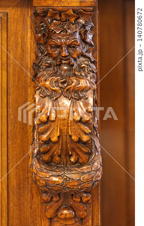 Green man wood carving decorating oak furniture detail 140780672