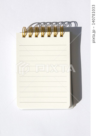 It is a small notebook placed on a white background. It is a small notebook placed on a white background. 140781033