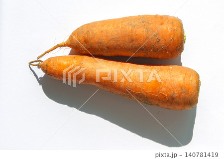 It is a close-up of a dirt-covered carrot. It is a close-up of a dirt-covered carrot. 140781419