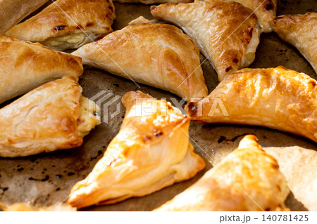 Puff pastry with cottage cheese. Puff pastry triangles with feta cheese on a protvin on a table Puff pastry with cottage cheese. Puff pastry triangles with feta cheese on a protvin on a table 140781425