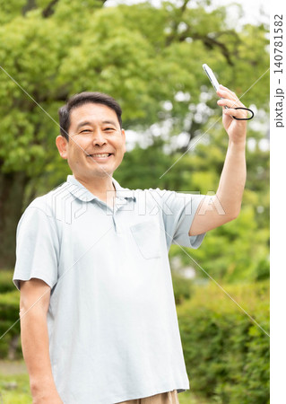 スマホを操作する中高年男性 スマホを操作する中高年男性 140781582
