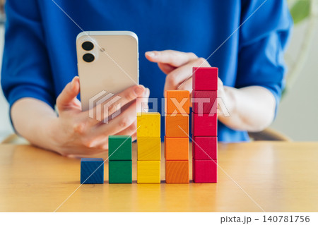 スマホで積立てる若い女性の手元 140781756