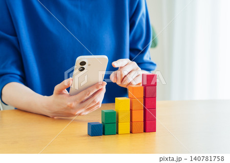 スマホで積立てる若い女性の手元 140781758