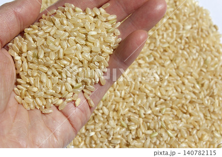 It is brown rice held in the hand. 140782115