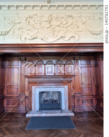 Elegant historic fireplace with carved wood paneling 140782781