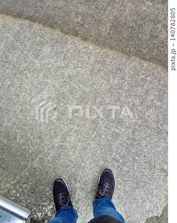 Standing on Concrete Sidewalk with Casual Shoes Standing on Concrete Sidewalk with Casual Shoes 140782805