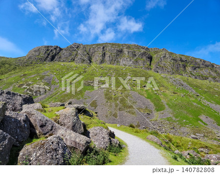 Mountain trail with rocky hillside and blue sky Mountain trail with rocky hillside and blue sky 140782808