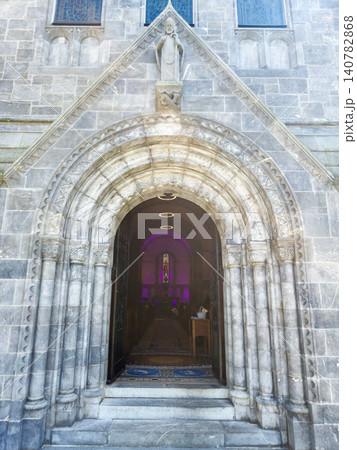 Ornate stone church entrance with arched doorway 140782868