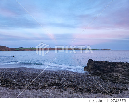 Tranquil rocky beach at twilight with pastel sky Tranquil rocky beach at twilight with pastel sky 140782876