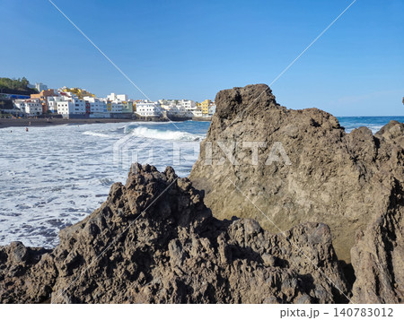 Rocky coastal beach with waves and seaside town Rocky coastal beach with waves and seaside town 140783012