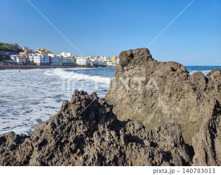 Rocky seaside coastline with village beach and waves Rocky seaside coastline with village beach and waves 140783013