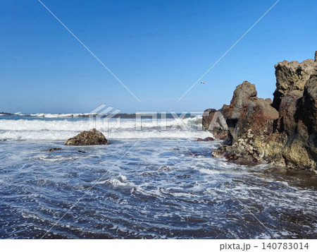 Rocky shoreline with ocean waves and blue sky Rocky shoreline with ocean waves and blue sky 140783014