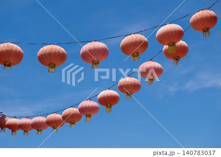 Colorful red paper lanterns hanging against a bright blue sky Colorful red paper lanterns hanging against a bright blue sky 140783037