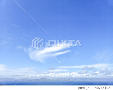 Blue sky over ocean with distant clouds and horizon Blue sky over ocean with distant clouds and horizon 140783102