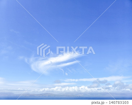 Blue sky with wispy clouds over distant seascape Blue sky with wispy clouds over distant seascape 140783103
