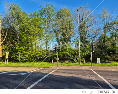 Quiet roadside intersection with traffic lights and trees 140783110