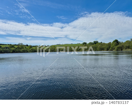 Peaceful lake landscape with blue sky and clouds Peaceful lake landscape with blue sky and clouds 140783137