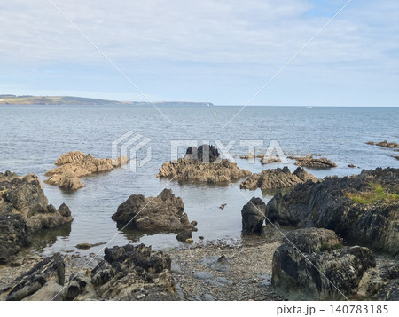 Rocky Seascape With Calm Ocean and Distant Coast Rocky Seascape With Calm Ocean and Distant Coast 140783185