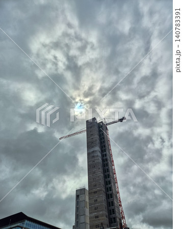 High-rise building construction under dramatic cloudy sky High-rise building construction under dramatic cloudy sky 140783391