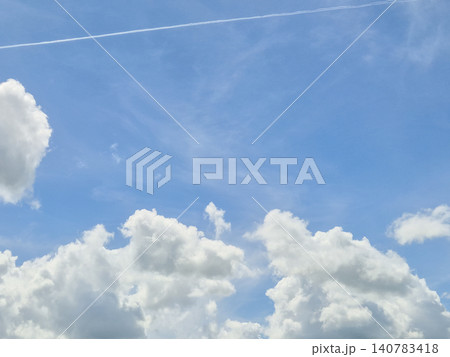 Blue sky with fluffy white clouds and contrails Blue sky with fluffy white clouds and contrails 140783418