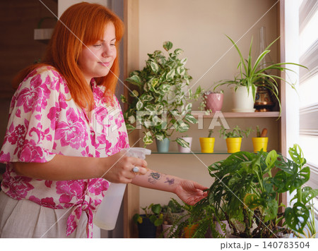 Young woman with beautiful houseplant in pot at home Young woman with beautiful houseplant in pot at home 140783504