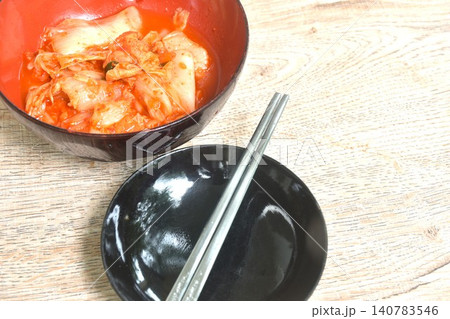 Kimchi pickled cabbage with sesame in salt Korean salad in red cup on table Kimchi pickled cabbage with sesame in salt Korean salad in red cup on table 140783546