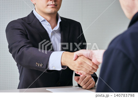握手をして契約や商談や業務提携や合意を交わす日本人男性会社員とビジネスパートナーの顔無しイメージ 握手をして契約や商談や業務提携や合意を交わす日本人男性会社員とビジネスパートナーの顔無しイメージ 140783798