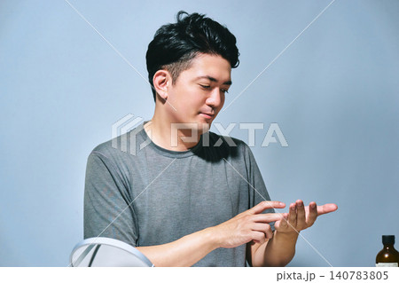 手のひらの美容液を確認する30代の日本人男性のアンチエイジングやメンズスキンケアイメージ 手のひらの美容液を確認する30代の日本人男性のアンチエイジングやメンズスキンケアイメージ 140783805