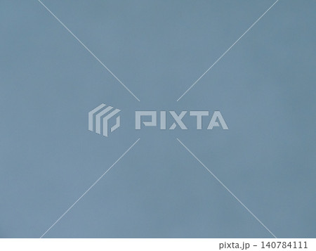 A minimalist matte background in a muted gray-blue. The uniform, smooth texture, without visible seams or defects, is reminiscent of a clean painted wall, thick paper, or a clear, overcast sky. A minimalist matte background in a muted gray-blue. The uniform, smooth texture, without visible seams or defects, is reminiscent of a clean painted wall, thick paper, or a clear, overcast sky. 140784111