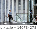 仕事の移動中にオフィスビルの階段を歩く半袖シャツを着た30代の日本人の男性の会社員 140784278