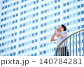 高層ビル街のテラスで大声で叫ぶメッセージを伝える半袖シャツを着た30代の日本人のビジネスマンの男性 140784281