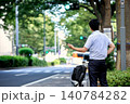 移動の為にスマートフォンのアプリで配車したタクシーを呼ぶ後ろ姿の顔無しの日本人のビジネスマンの男性 140784282
