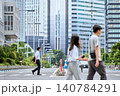 都会の道路の横断歩道を歩く半袖シャツを着た30代の日本人のビジネスマンの男性と行き交う人々の様子 140784291