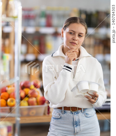 Girl choosing yogurt in the store Girl choosing yogurt in the store 140784303