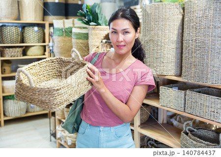 Asian female standing with basket in shop Asian female standing with basket in shop 140784437
