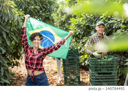 Smiling farmers holding flag of Brazil in avocado plantation 140784491