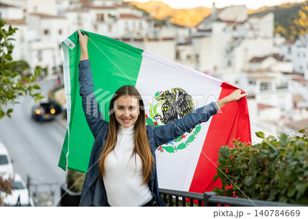 Excited young female traveler waving Mexican flag on street, sport fan supporter 140784669