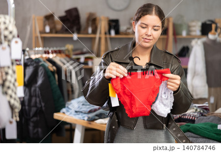 Young woman chooses panties in clothing store Young woman chooses panties in clothing store 140784746