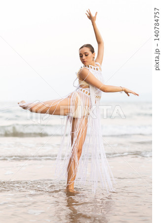Barefoot girl on seashore in sexy and revealing Amazon tribe carnival costume. Barefoot girl on seashore in sexy and revealing Amazon tribe carnival costume. 140784757