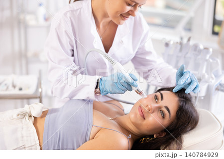 Young girl getting hardware facial procedure using ion bubble pen Young girl getting hardware facial procedure using ion bubble pen 140784929